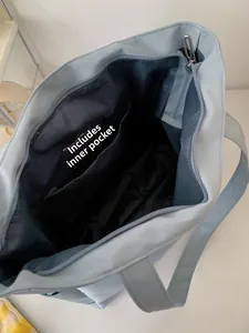 Top-down detail of the light blue tote bag interior with pocket and metal zipper
