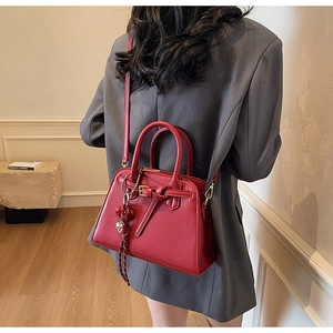Dettaglio della borsa da sposa rossa con elegante design a nodo e chiusura dorata
