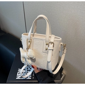 Detailansicht der weißen Mini-Tasche mit Sternprägung und einem süßen Hundeanhänger