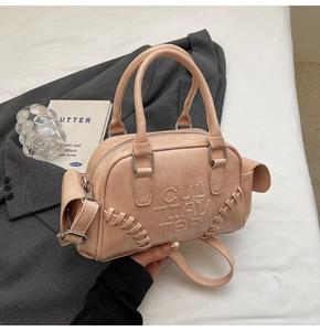 Detail of nude pink Boston bag showing Cultiavter embossing and woven rope accents