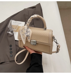 Détail du sac à bandoulière en patchwork tissé avec poignée en cuir brun et foulard en soie
