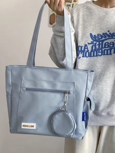 Detail of light blue tote bag with extra pockets and detachable round coin purse