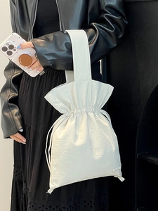 Minimalist white drawstring nylon handbag with wide strap shown on a model
