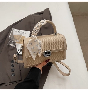 Détail du sac à rabat tissé beige avec poignée en foulard de soie et fermoir argenté