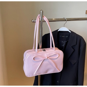 Detailed view of a pink bow tote bag featuring a glossy PU leather finish and zipper closure