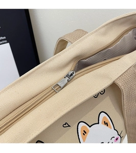 Detail of metal zipper closure and high-quality canvas texture on a beige tote bag