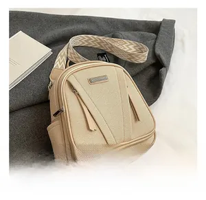 Detailansicht eines beigen Canvas-Rucksacks mit breitem Trageriemen im ethnischen Webmuster