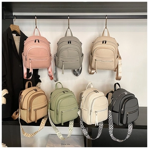 Close-up of mini PU leather backpacks in multiple colors with patterned woven straps