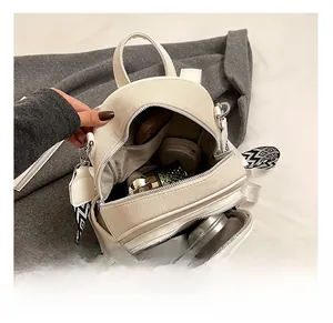 Detailed interior of a cream mini backpack showing makeup essentials and textured fabric