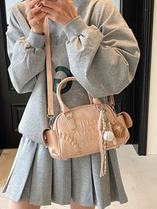 Pink sporty barrel bag with baseball charms and decorative stitching for women