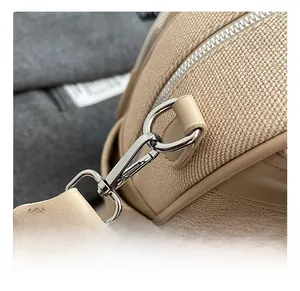 Detailsicht des silbernen Metallhakens und der Textur auf dem stilvollen beigen Rucksack
