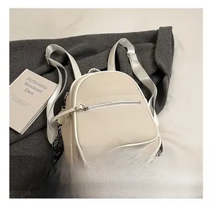 Detail of off-white canvas backpack with textured fabric and zig-zag patterned strap
