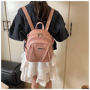 Rosa Damenrucksack mit körniger Textur und mehreren Reißverschlussfächern für Reisen