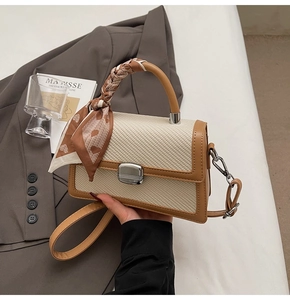 Détail du petit sac carré bicolore avec texture tissée et foulard cœur au manche