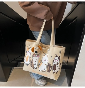 Detail of canvas tote bag with cartoon cat print and plush dog charm on handle