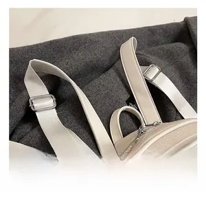 Detail view of beige knitted backpack with adjustable fabric strap and silver buckle