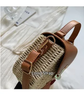 Detailed close-up of woven straw texture with adjustable brown leather shoulder strap