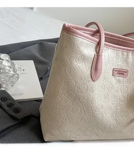 Detail of embossed koi and lotus patterns on beige tote bag with pink leather trim