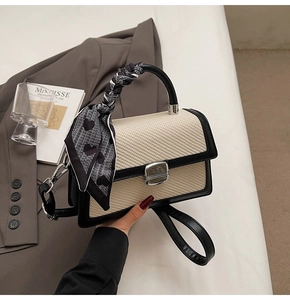 Détail du petit sac carré tissé avec bordure en cuir noir et foulard en soie à cœurs