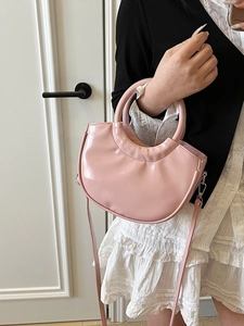 Chic pink patent leather bucket bag with circular handle and crossbody strap for women