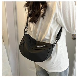 Detail of black nylon crescent saddle bag with wide adjustable strap on model