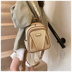 Detail of beige woven backpack with brown leather trim and patterned jacquard strap