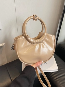 Khaki half-moon handbag with a large circular handle and shiny textured faux leather finish