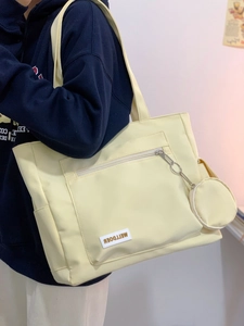Detail of cream tote bag with front zipper pocket and detachable round coin purse