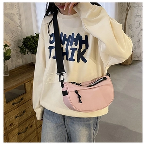 Detail of pink crescent crossbody bag with wide nylon strap and fashion logo webbing