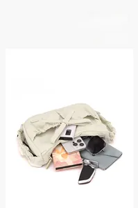Spacious main compartment of the beige nylon tote bag showing everyday essentials inside