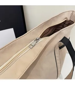 Detail eines silbernen Metallreißverschlusses und gestreiften Futters am beigen Shopper