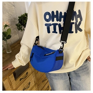 Close-up of Klein blue nylon saddle bag featuring a wide black strap and buckle detail