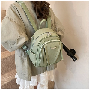 Fashionable pea green mini backpack with multiple zipper pockets shown on a model