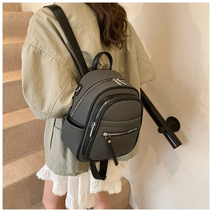 Detail of dark grey mini backpack showing high-density texture and leather accents