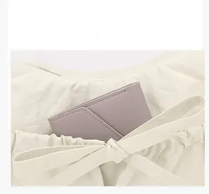 Close-up of front pocket functionality on a cream nylon tote bag with a purple wallet