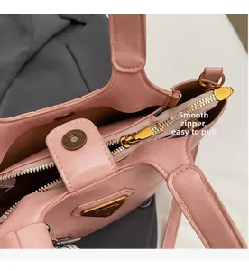 Détail d'un sac seau rose montrant la fermeture éclair dorée et le cuir grainé