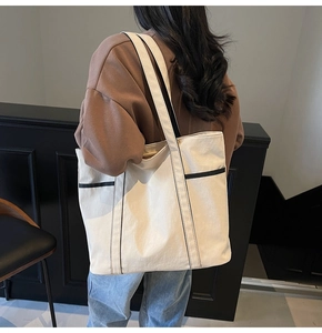 Große Canvas-Tragetasche mit schwarzem Besatz über der Schulter im Lifestyle-Look