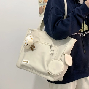 Creamy white canvas tote bag side view featuring round coin purse and mushroom charm