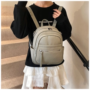 Lifestyle shot of light gray versatile backpack with front pocket on female model