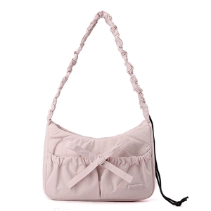 Detail of light pink nylon tote bag with bow decoration and pleated shoulder strap