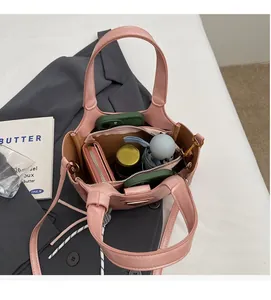 Sac cabas en cuir rose avec intérieur spacieux contenant téléphone, portefeuille et parapluie