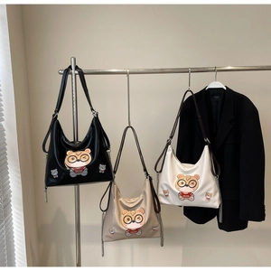 Three versatile tote bags in black, beige, and white with cartoon bear and chain strap