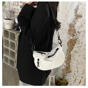 Detailed shot of white nylon hobo bag with adjustable black strap and fashion label detail