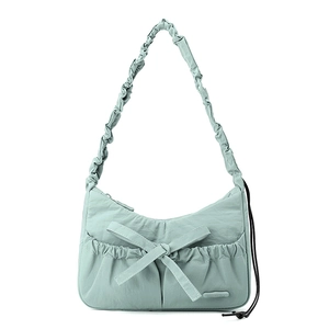 Detail of mint green nylon tote with large bow, drawstring pockets and ruched strap