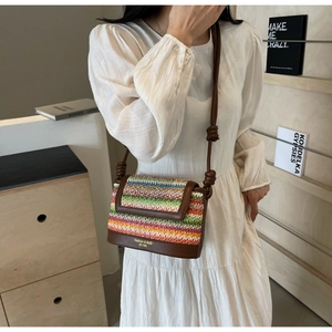 Detailed macro view of the rainbow woven crossbody bag with brown leather strap and gold logo