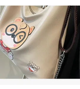 Detail of lychee pattern faux leather tote bag featuring a cute cartoon bear print