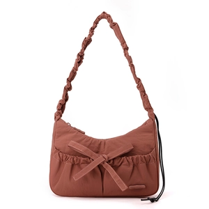 Detail of burgundy nylon shoulder bag with pleated handle and bow knot decoration