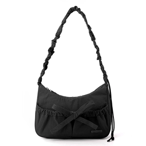Close-up of black nylon tote bag with decorative bow and gathered cloud shoulder strap
