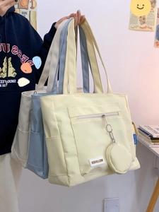 Detail of canvas tote bag with side pockets and mini round coin purse attachment