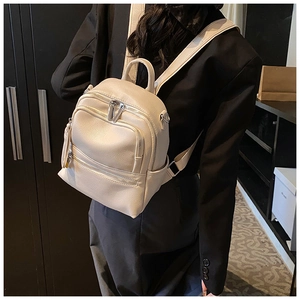 Close-up of a cream white mini backpack with pebble leather texture and silver zippers